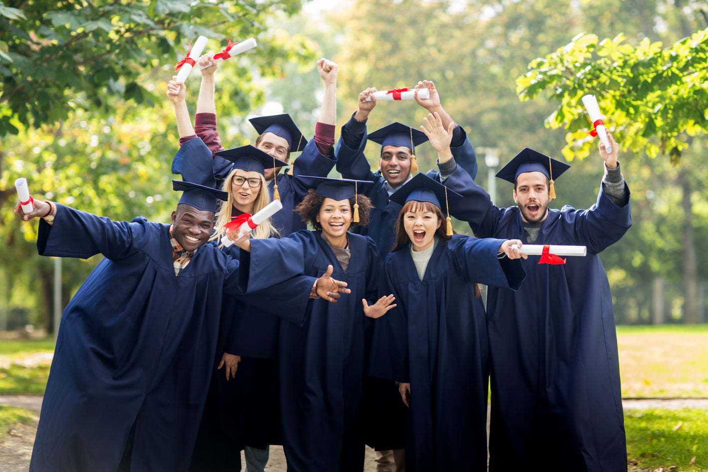 Graduates in Gowns with Diplomas